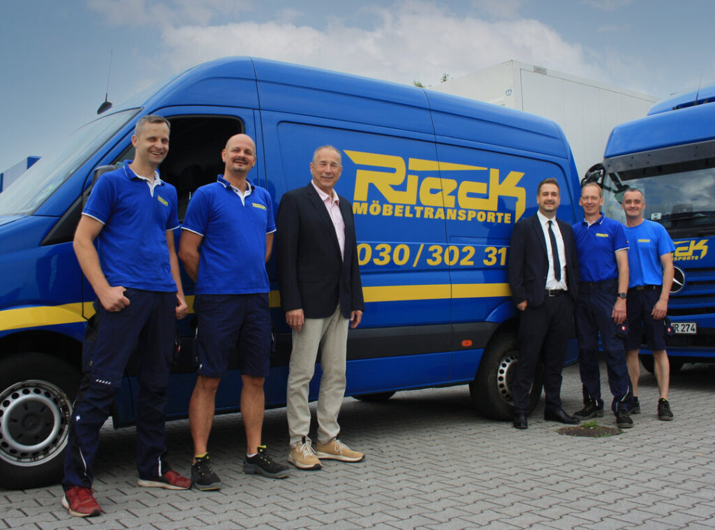 Eine Gruppe Männer vor einem Rieck Transporter.