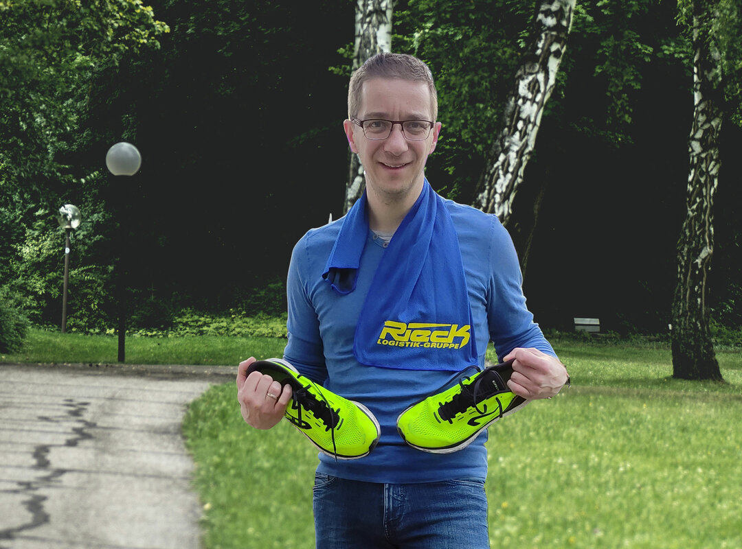 Marcel Uhr hält Sportschuhe in beiden Händen.