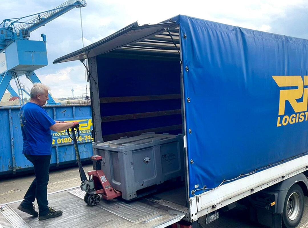 Ein Rieck-Mitarbeiter, der einen Lkw mit Boxen belädt.