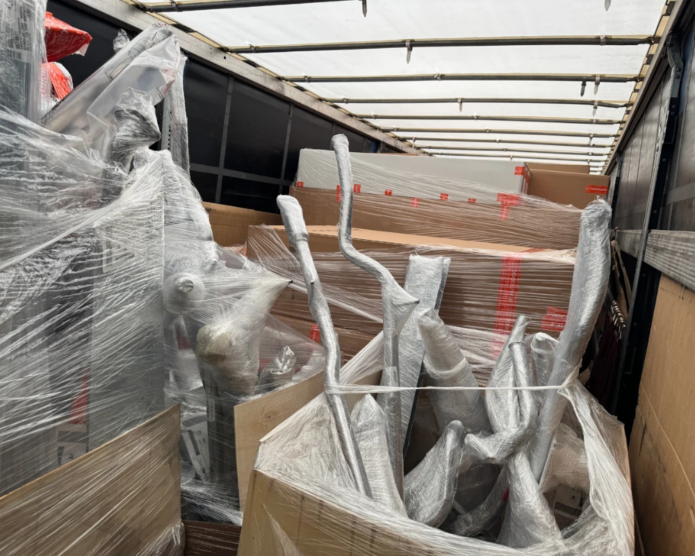 Verpackte Möbelteile und Kartons in einem LKW-Laderaum.