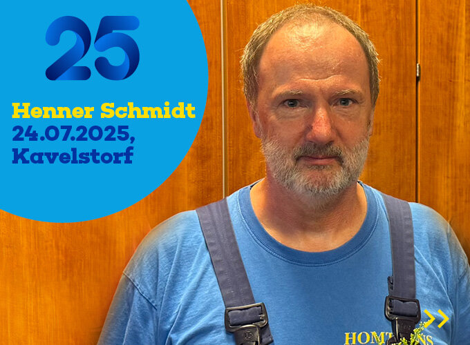 Mann mit blauem T-Shirt und Latzhose vor Holzwand, daneben Text mit Namen, Datum und Ort.