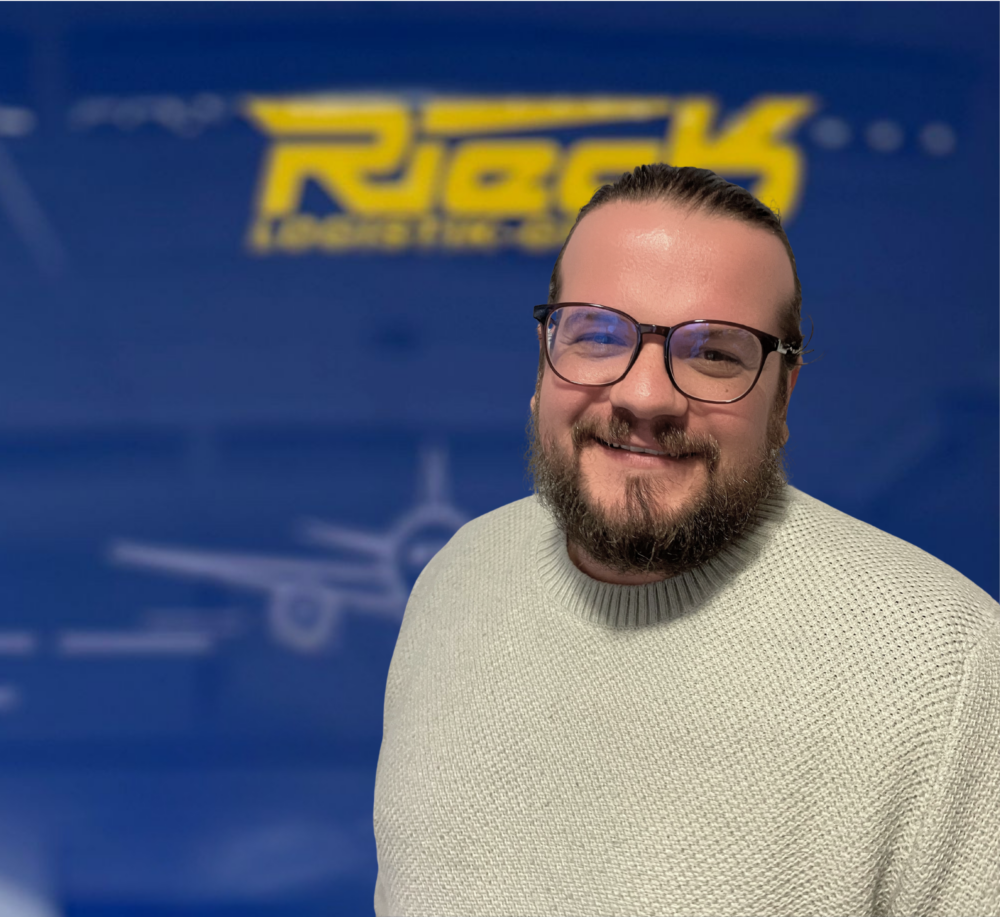 Mann mit Brille und Bart vor blauem Hintergrund mit gelbem Schriftzug.