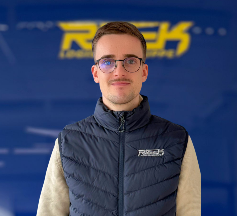 Junger Mann mit Brille und Weste vor blauem Hintergrund mit gelbem Schriftzug.